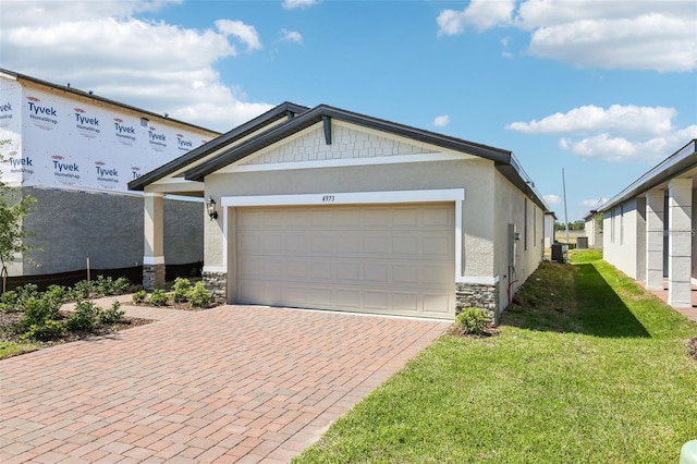 4973 Kaia Ave, Winter Haven, FL 33884 - view of front of property featuring stone siding, a front lawn, decorative driveway, and stucco siding