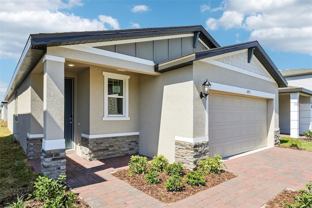 4973 Kaia Ave, Winter Haven, FL 33884 - view of front of home featuring stone siding, a garage, stucco siding, decorative driveway, and board and batten siding