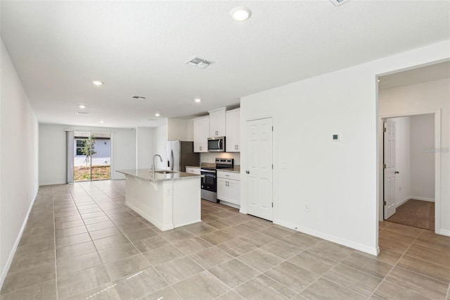 4973 Kaia Ave, Winter Haven, FL 33884 - kitchen with stainless steel appliances, a sink, white cabinetry, recessed lighting, and a center island with sink