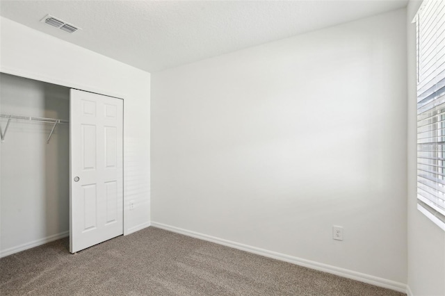 4973 Kaia Ave, Winter Haven, FL 33884 - unfurnished bedroom with carpet floors, multiple windows, a closet, and baseboards