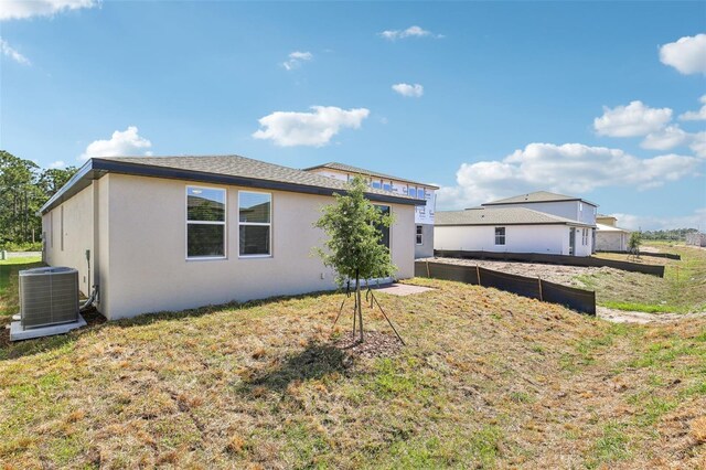 4973 Kaia Ave, Winter Haven, FL 33884 - view of home's exterior featuring stucco siding, cooling unit, and a lawn