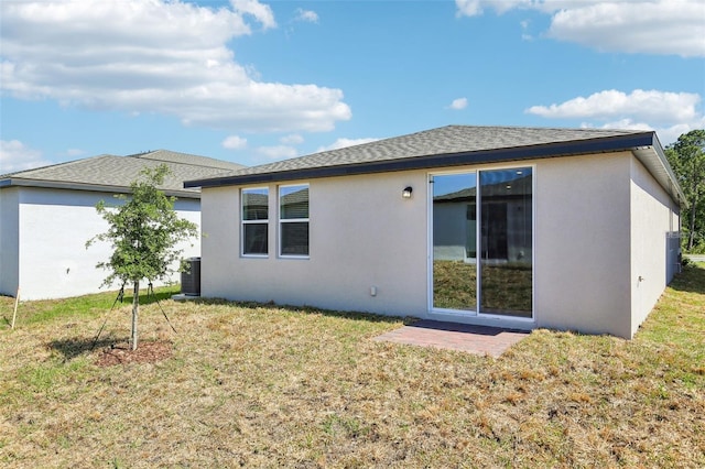 4973 Kaia Ave, Winter Haven, FL 33884 - back of house with stucco siding, a lawn, and a shingled roof