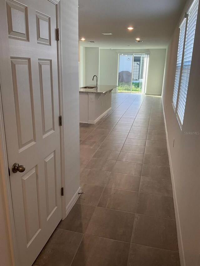 4957 Kaia Ave, Winter Haven, FL 33884 - corridor with baseboards, dark tile patterned flooring, a sink, and recessed lighting