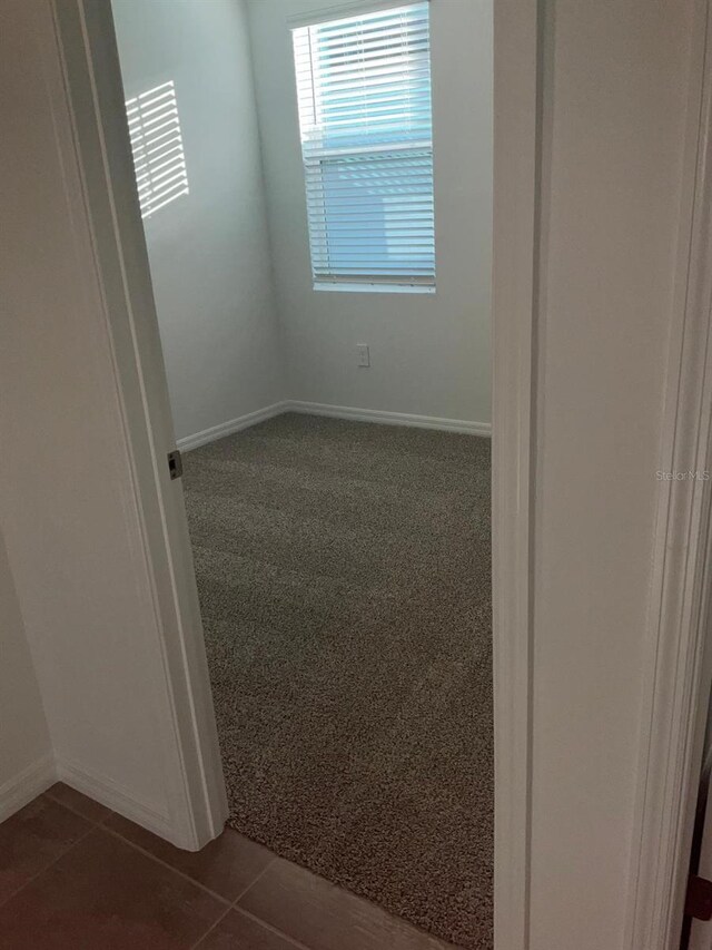 4957 Kaia Ave, Winter Haven, FL 33884 - spare room featuring baseboards, dark carpet, and dark tile patterned floors