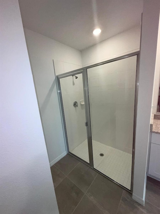 4957 Kaia Ave, Winter Haven, FL 33884 - bathroom featuring a shower stall, tile patterned flooring, vanity, and baseboards