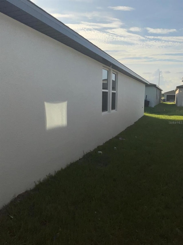 4957 Kaia Ave, Winter Haven, FL 33884 - view of side of property with stucco siding and a lawn