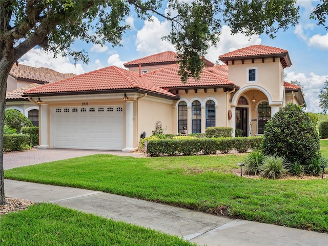 9335 San Jose Blvd, Howey In The Hills, FL 34737 - mediterranean / spanish-style home with stucco siding, a garage, a front lawn, driveway, and a tile roof
