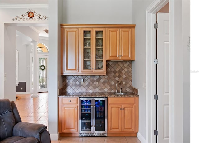 9335 San Jose Blvd, Howey In The Hills, FL 34737 - indoor wet bar featuring wine cooler, light tile patterned flooring, tasteful backsplash, ornamental molding, and ornate columns