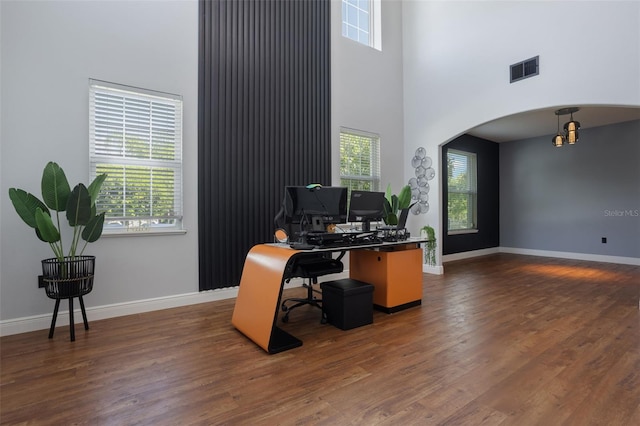 637 Neptune Dr, Groveland, FL 34736 - office space featuring arched walkways, a high ceiling, dark wood finished floors, and baseboards