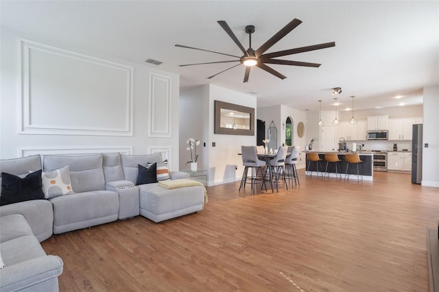 637 Neptune Dr, Groveland, FL 34736 - living area featuring ceiling fan, light wood-type flooring, and baseboards