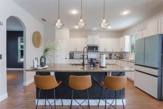 637 Neptune Dr, Groveland, FL 34736 - kitchen featuring freestanding refrigerator, stainless steel microwave, white cabinets, and recessed lighting