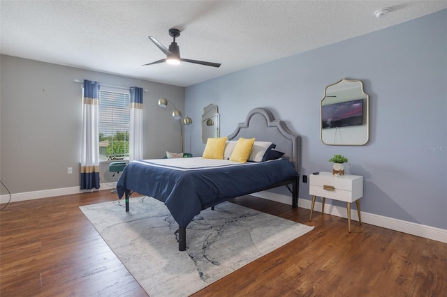 637 Neptune Dr, Groveland, FL 34736 - bedroom featuring wood finished floors, a textured ceiling, baseboards, and a ceiling fan