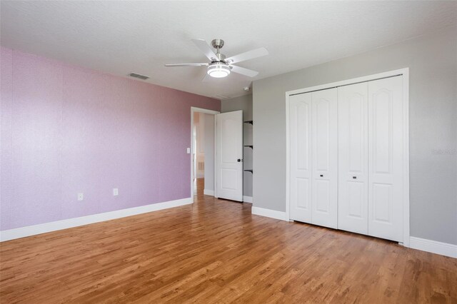 637 Neptune Dr, Groveland, FL 34736 - unfurnished bedroom with light wood-type flooring, baseboards, a closet, and a ceiling fan