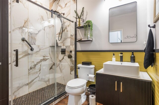 637 Neptune Dr, Groveland, FL 34736 - bathroom featuring toilet, wainscoting, a marble finish shower, vanity, and wood finished floors