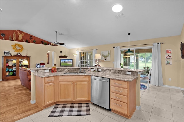 17355 SE 110th Ter, Summerfield, FL 34491 - kitchen with stainless steel dishwasher, a sink, lofted ceiling, light brown cabinets, and a ceiling fan