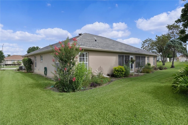 17355 SE 110th Ter, Summerfield, FL 34491 - rear view of house featuring stucco siding, a yard, central AC unit, and roof with shingles