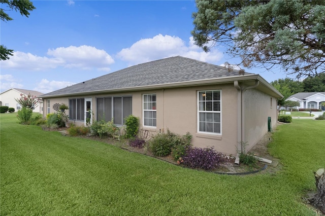 17355 SE 110th Ter, Summerfield, FL 34491 - back of house with a lawn, stucco siding, and roof with shingles