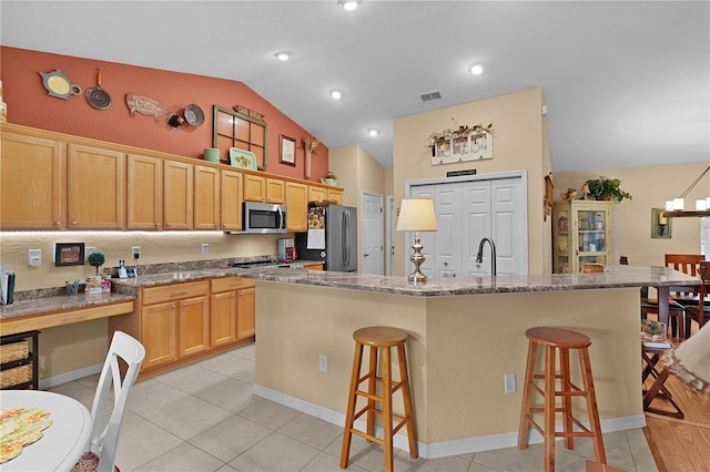 17355 SE 110th Ter, Summerfield, FL 34491 - kitchen featuring stainless steel microwave, a kitchen bar, a spacious island, light tile patterned flooring, and high vaulted ceiling