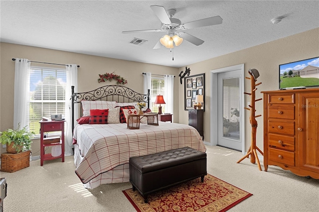 17355 SE 110th Ter, Summerfield, FL 34491 - bedroom with light carpet, a textured ceiling, access to outside, and a ceiling fan