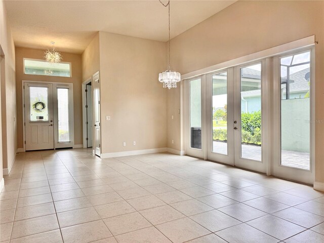 3021 King Palm Dr, New Smyrna Beach, FL 32168 - entryway featuring a chandelier, light tile patterned floors, a towering ceiling, and french doors