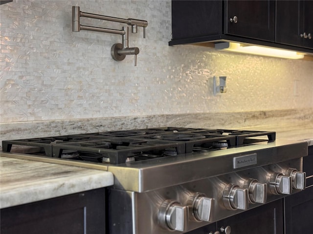 3021 King Palm Dr, New Smyrna Beach, FL 32168 - kitchen view of pot filler, range, decorative backsplash, dark cabinetry, and light countertops
