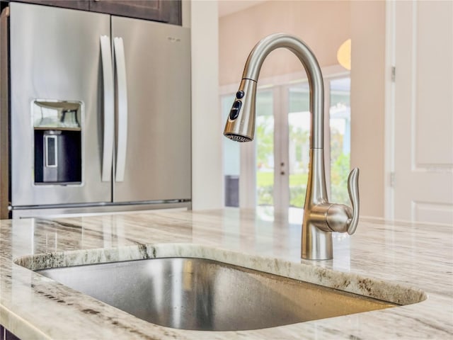 3021 King Palm Dr, New Smyrna Beach, FL 32168 - kitchen view of stainless steel fridge, light stone countertops, french doors, and dark brown cabinetry