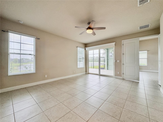 3021 King Palm Dr, New Smyrna Beach, FL 32168 - unfurnished room featuring a ceiling fan, light tile patterned floors, healthy amount of natural light, and a textured ceiling
