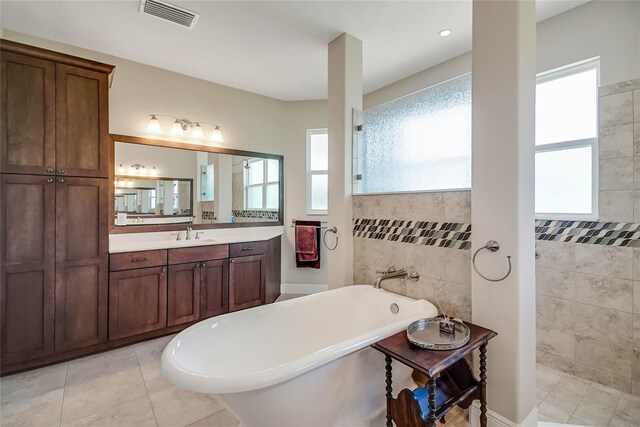 6008 Apex Way, Lady Lake, FL 32159 - full bath featuring a soaking tub, vanity, healthy amount of natural light, tile patterned floors, and tile walls