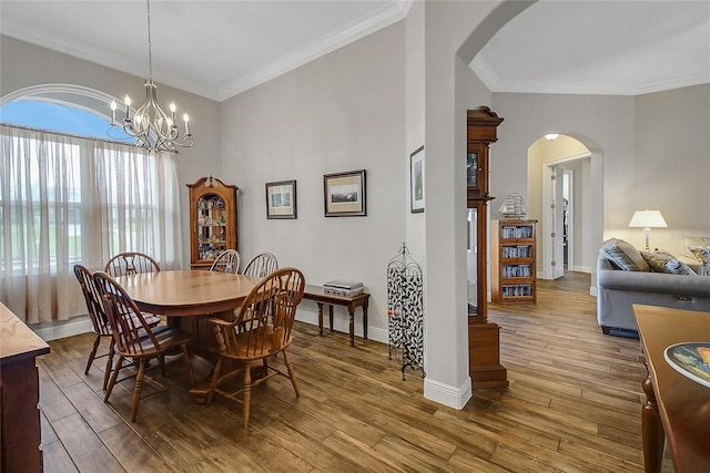6008 Apex Way, Lady Lake, FL 32159 - dining room with arched walkways, ornamental molding, wood finished floors, baseboards, and a chandelier