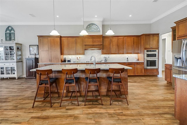 6008 Apex Way, Lady Lake, FL 32159 - kitchen featuring appliances with stainless steel finishes, brown cabinets, crown molding, tasteful backsplash, and wood finished floors