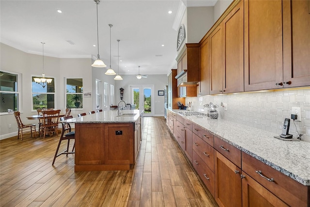 6008 Apex Way, Lady Lake, FL 32159 - kitchen featuring a sink, baseboards, brown cabinets, backsplash, and ornamental molding