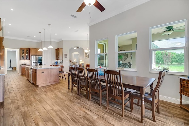 6008 Apex Way, Lady Lake, FL 32159 - dining space with a ceiling fan, light wood-style floors, arched walkways, ornamental molding, and baseboards