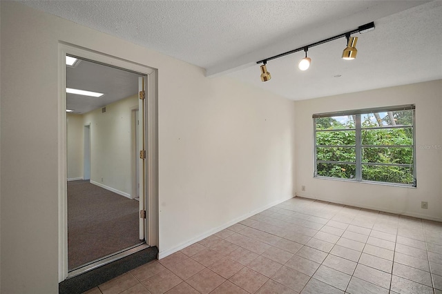 27113 Robertson Rd, Yalaha, FL 34797 - spare room with a textured ceiling, tile patterned floors, and rail lighting