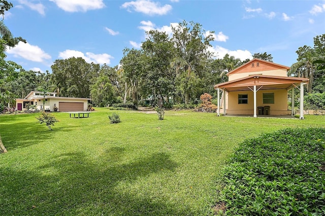 27113 Robertson Rd, Yalaha, FL 34797 - view of green lawn featuring view of wooded area and a garage