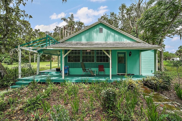 27113 Robertson Rd, Yalaha, FL 34797 - view of front of house featuring a shingled roof and covered porch