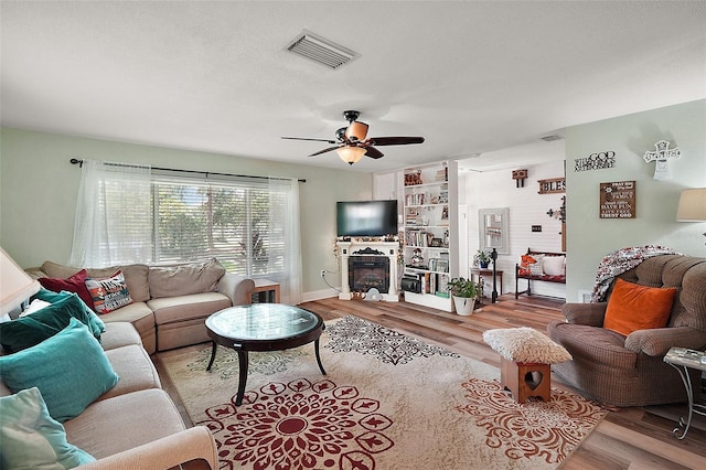 27212 Orange Ave, Yalaha, FL 34797 - living area featuring a glass covered fireplace, light wood finished floors, and ceiling fan