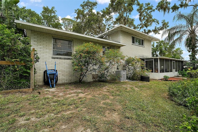 27212 Orange Ave, Yalaha, FL 34797 - rear view of property featuring a sunroom, brick siding, and a yard