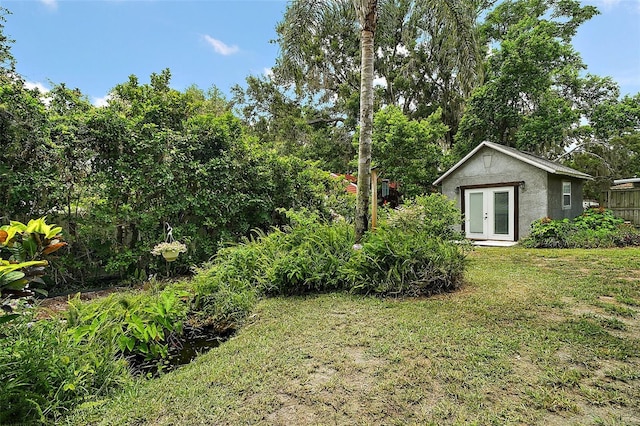 27212 Orange Ave, Yalaha, FL 34797 - view of grassy yard featuring french doors, an outdoor structure, and view of scattered trees