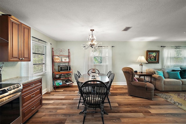 27212 Orange Ave, Yalaha, FL 34797 - dining area featuring a chandelier, dark wood-type flooring, and a textured ceiling