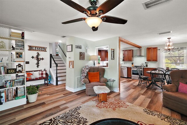 27212 Orange Ave, Yalaha, FL 34797 - living room with light wood finished floors, stairs, a ceiling fan, and a chandelier