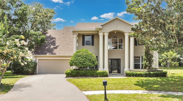 17300 Summer Sun Ct, Clermont, FL 34711 - view of front of home with stucco siding, driveway, a front lawn, a garage, and roof with shingles