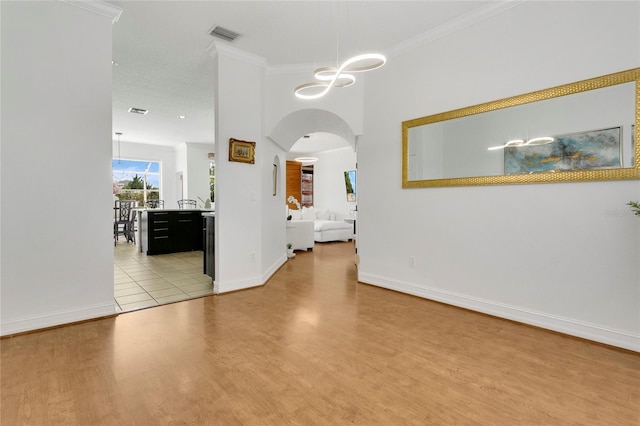 17300 Summer Sun Ct, Clermont, FL 34711 - spare room with arched walkways, light wood-style floors, ornamental molding, baseboards, and a chandelier