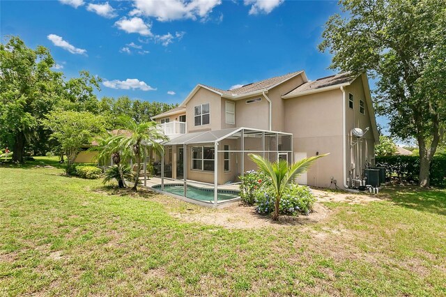 17300 Summer Sun Ct, Clermont, FL 34711 - rear view of property with an outdoor pool, stucco siding, glass enclosure, central AC unit, and a lawn