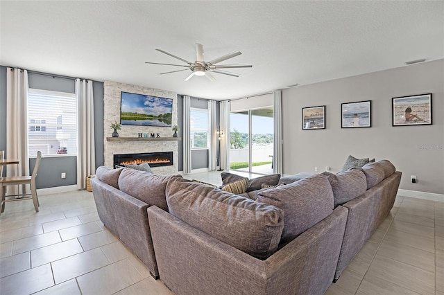 391 Cheeota Ct, Minneola, FL 34715 - living room featuring ceiling fan, a stone fireplace, and light tile patterned flooring