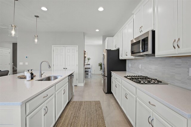 391 Cheeota Ct, Minneola, FL 34715 - kitchen featuring appliances with stainless steel finishes, backsplash, an island with sink, white cabinetry, and recessed lighting