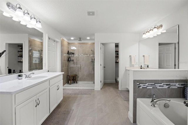 391 Cheeota Ct, Minneola, FL 34715 - bathroom featuring a stall shower, vanity, a bath, and recessed lighting