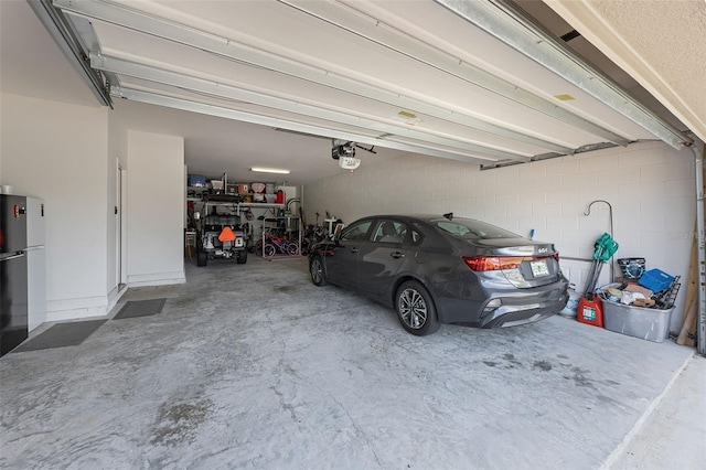 391 Cheeota Ct, Minneola, FL 34715 - garage featuring freestanding refrigerator and a garage door opener