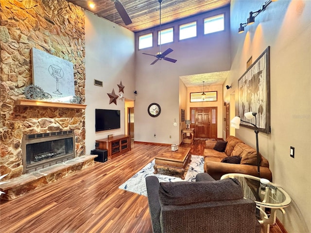 3664 SE 45th Pl, Ocala, FL 34480 - living area featuring wood finished floors, a ceiling fan, a towering ceiling, a stone fireplace, and wooden ceiling