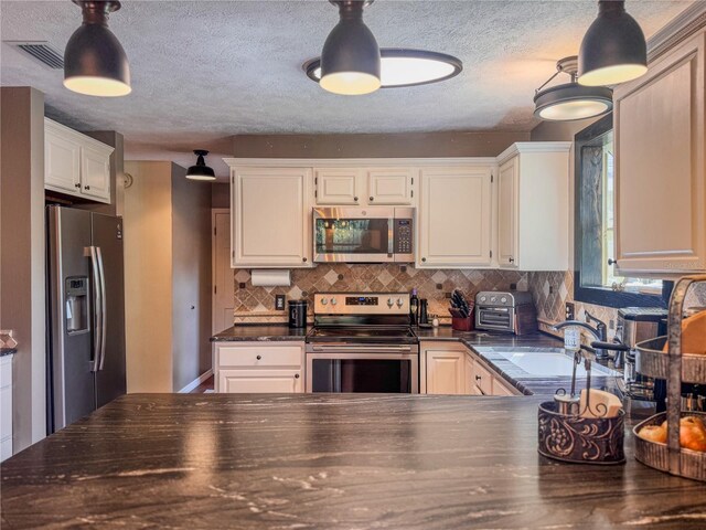 3664 SE 45th Pl, Ocala, FL 34480 - kitchen featuring appliances with stainless steel finishes, dark countertops, decorative backsplash, white cabinetry, and a textured ceiling