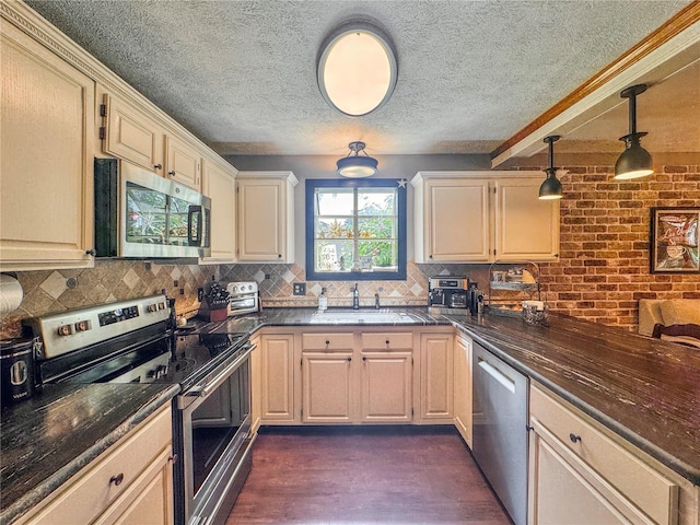 3664 SE 45th Pl, Ocala, FL 34480 - kitchen featuring appliances with stainless steel finishes, a textured ceiling, tasteful backsplash, dark wood-style flooring, and pendant lighting